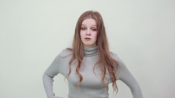 Frau im grauen Pullover mit bösem Blick zeigt Wut, Sturheit, Hass, Faust - Filmmaterial, Video