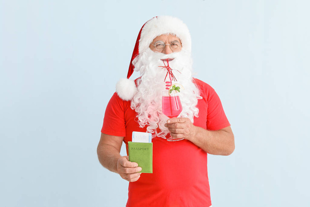 Papai Noel com documentos e coquetel no fundo claro. Conceito de férias
 - Foto, Imagem