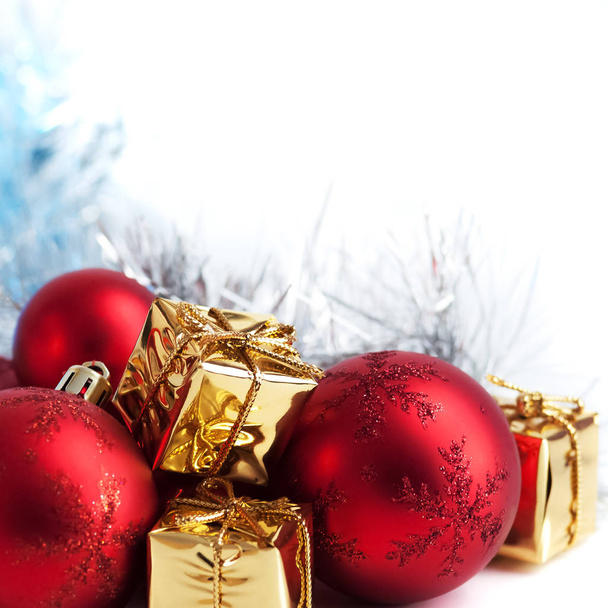 Merry Christmas, New Year, gifts in gold boxes, red Christmas balls are piled in the left corner. White background - Photo, image