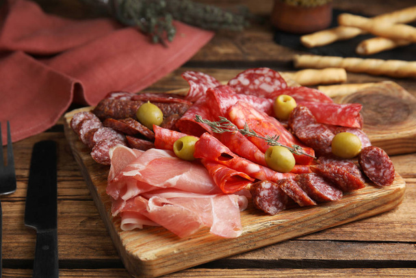 Tasty prosciutto with other delicacies served on wooden table - Fotoğraf, Görsel