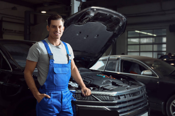 Mechanic near automobile in service center, space for text. Car diagnostic - Foto, afbeelding