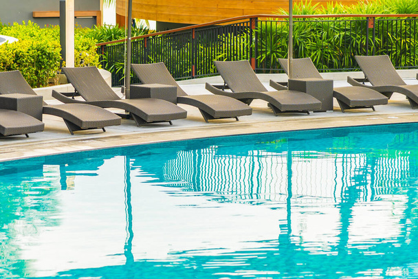 Umbrella and chair sofa around outdoor swimming pool in hotel re - Foto, imagen