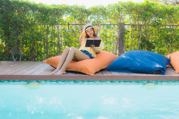 Retrato joven asiático mujer leer libro alrededor al aire libre natación poo
 - Foto, imagen
