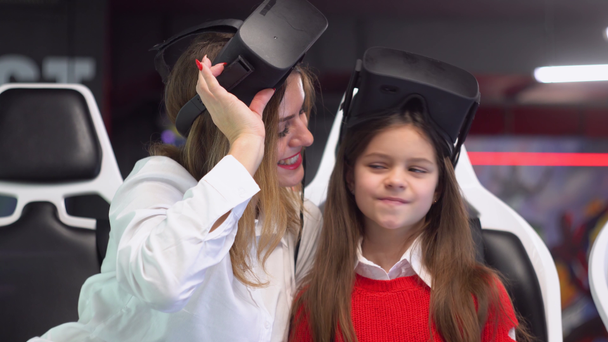 Mulher e filha felizes depois de jogar simulador de realidade virtual
 - Filmagem, Vídeo