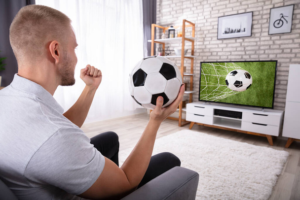 Excited Man Enjoying Football Match On Television At Home - Foto, imagen