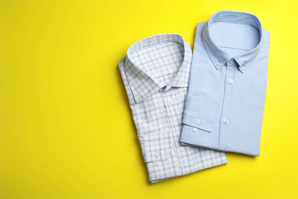 Stylish male shirts on yellow background, flat lay. Space for te - Foto, Imagen
