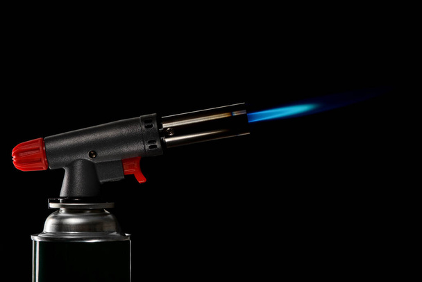 gas burner with piezo ignition with burning flame on black background - Foto, Imagem
