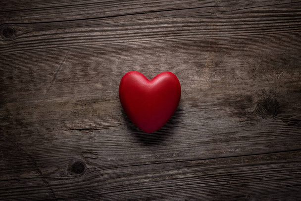 Red heart on vintage wooden background. Valentine day concept. Top view red heart on old wood texture background with copy space for text. - Foto, Imagen
