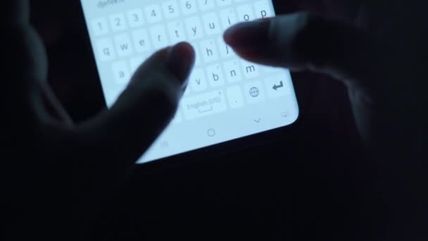 Manos escribiendo texto en el primer plano del smartphone. Usando el teléfono inteligente de cerca por la noche
. - Imágenes, Vídeo