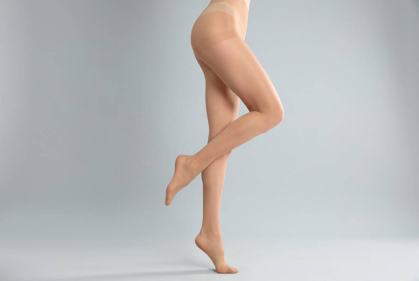Woman wearing tights on light grey background, closeup of legs - Photo, Image