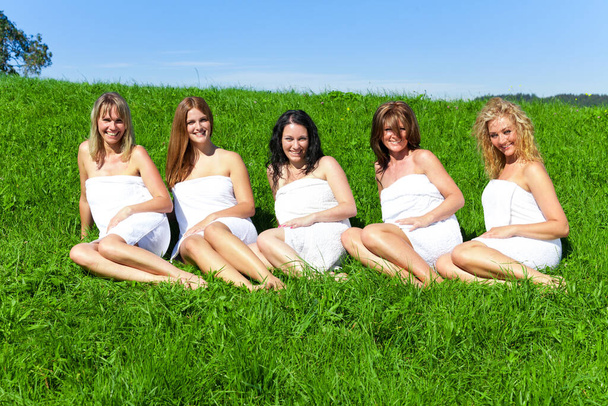 Woman group in towel on the summer meadow - 写真・画像