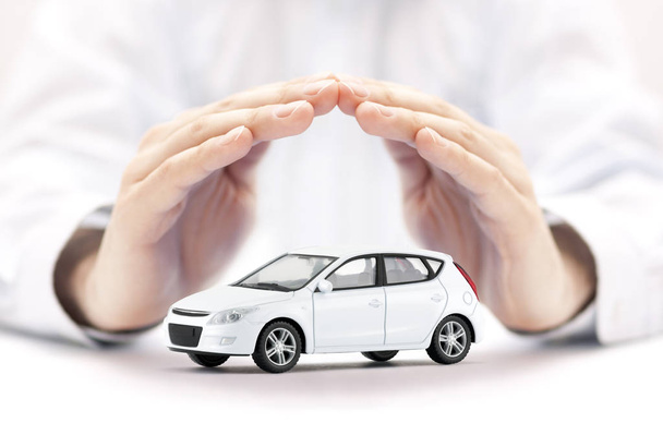 Car insurance. Small white car covered by hands. - Foto, Imagen