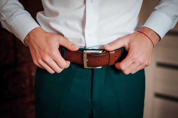 Close up man holding hands on his belt - Foto, Imagen