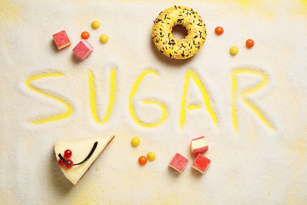 Flat lay composition with sweets and word SUGAR on yellow background - Fotoğraf, Görsel