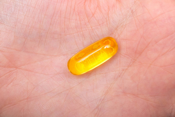 Omega 3 capsules in woman hands - Fotó, kép