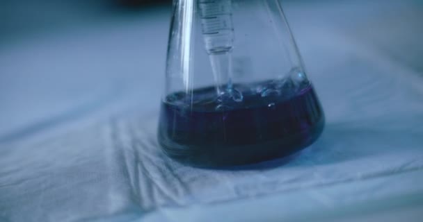 Kuplia, jotka tulevat erlenmeyerpullossa olevasta mittapipetistä laboratoriossa suoritetussa kemikaalikokeessa. Lähemmäs, kädessä, hidastettuna, ammuttu BMPCC 4K: lla. Käsite: tiede, kemia
 - Materiaali, video