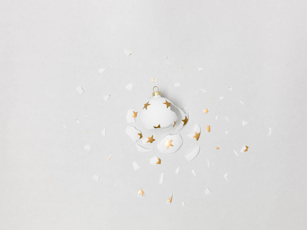 great exploding white bauble with golden stars on it on grey background in the studio - Photo, Image
