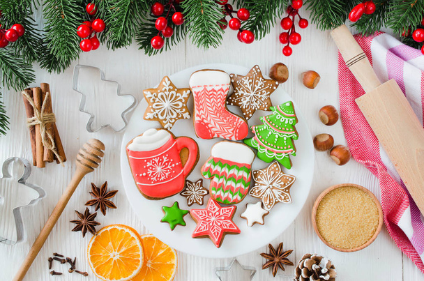 Holiday food background. Gingerbread cookies with cutters, rolling pin and ingredients for baking on white wooden table. Top view. - Φωτογραφία, εικόνα