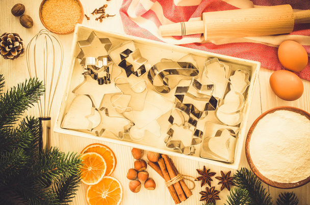 Holiday food background. Christmas cookie cutters, rolling pin and ingredients for baking on white wooden table. Top view. - Fotó, kép