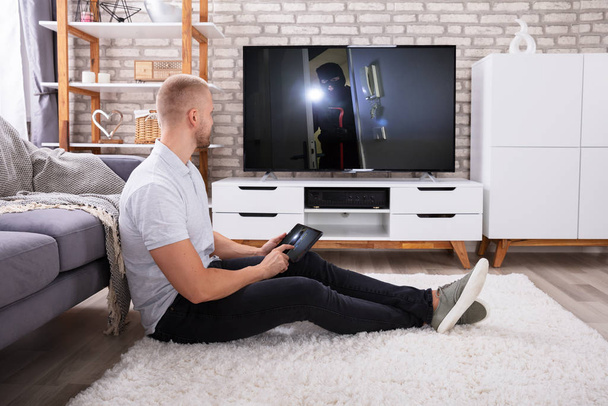 Man Streaming Television Channel Through Wireless Connection On Digital Tablet - Φωτογραφία, εικόνα