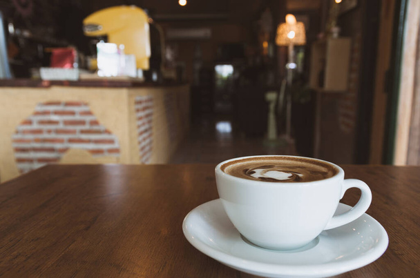 A coffee cup on wooden table in coffee shop and copy space. - Foto, Bild