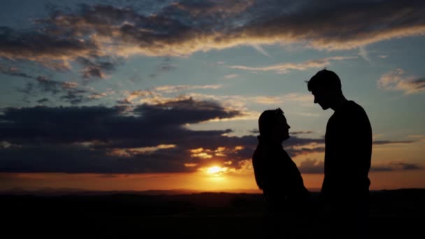 Neuvěřitelný západ slunce se siluetami dvou zamilovaných lidí. Romantická atmosféra - Záběry, video