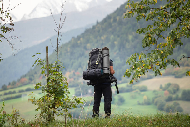 A hiker with a backpack looks into the distance - Foto, Imagem