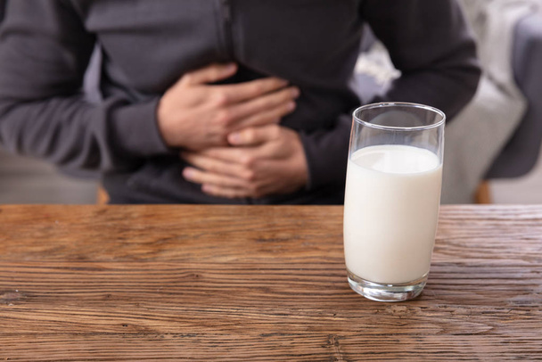 Midsection View Of A Man Suffering From Stomach Pain Holding Glass Of Milk - Foto, Bild