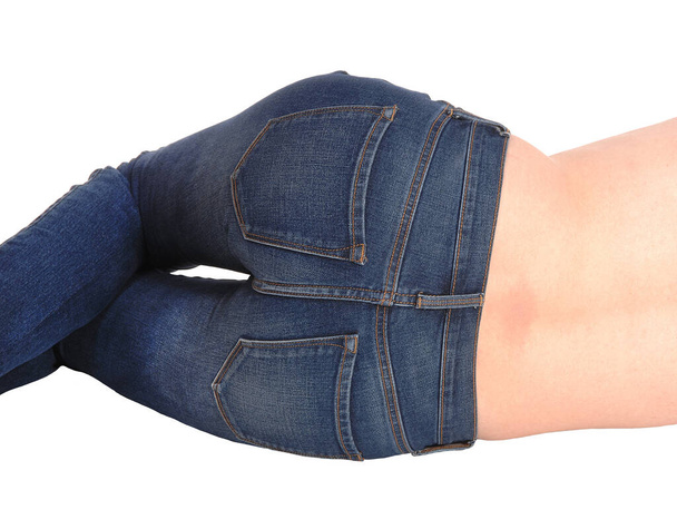The bottom of a young woman wearing jeans in close-up, body parts.lying on the floor from the back, isolated for white background. - Photo, Image