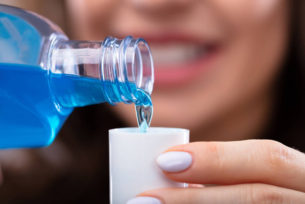 Close-up Of A Woman's Hand Pouring Mouthwash Into Cap - Φωτογραφία, εικόνα
