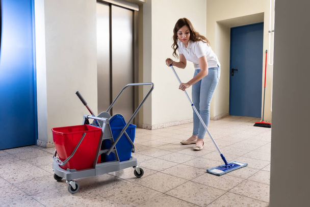 Young Female Janitor Cleaning Floor With Mop In Corridor - Photo, Image