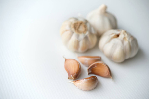 Garlic cloves and bulb with copy space on grey background. - Foto, afbeelding
