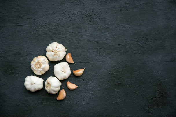 Top view garlic cloves and bulb with copy space on dark background. - Valokuva, kuva