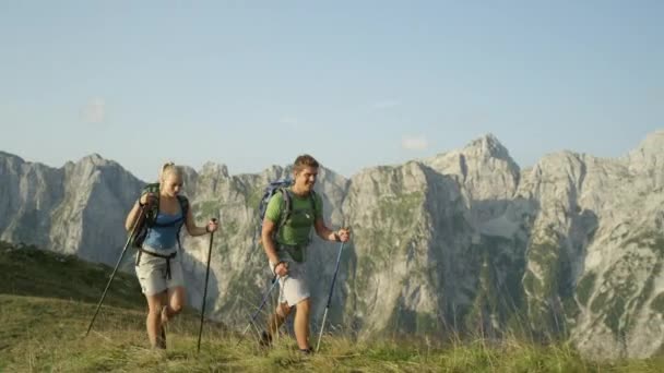 Wesoła para trekkerów ciesząca się widokami podczas wędrówki po Alpach Julijskich. - Materiał filmowy, wideo