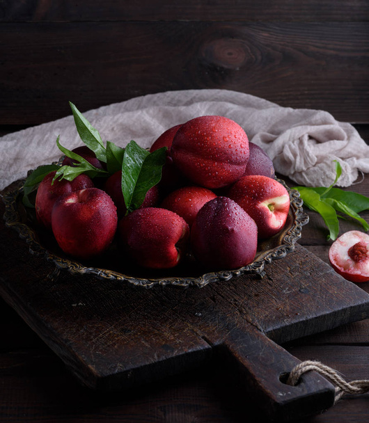 red ripe peaches nectarine in an iron plate, close up - Foto, immagini