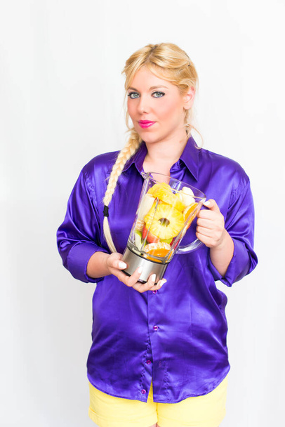 Blonde woman with a blender full of fruit - Φωτογραφία, εικόνα