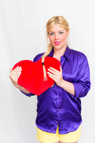 Blonde woman with heart in Hand - Фото, изображение