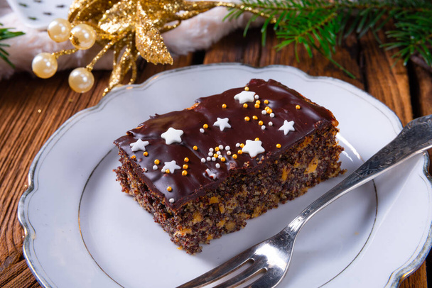 Christmas poppy seed cake with chocolate, nuts and raisins - Photo, Image