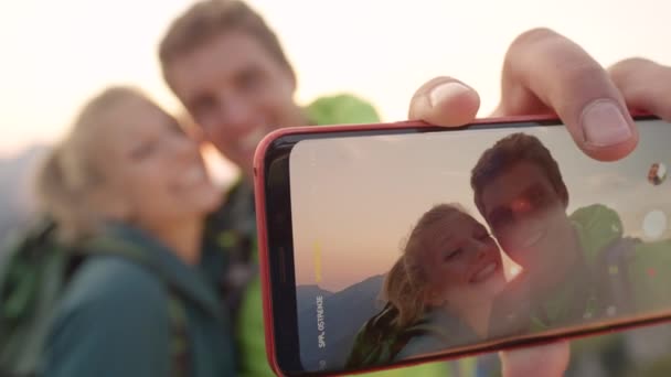 Makro, dof: Glückliches Wanderpaar macht bei Sonnenaufgang ein Selfie hoch oben in den Alpen. - Filmmaterial, Video