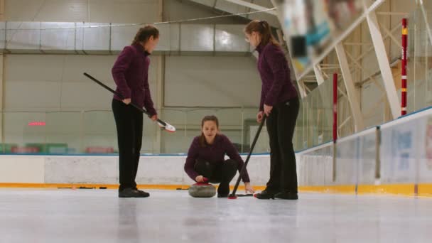 Curling training indoors - pushing the granite stone biter and rubbing the ice before the biter - Video, Çekim