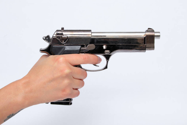Woman holding gun in hand - Foto, Imagen