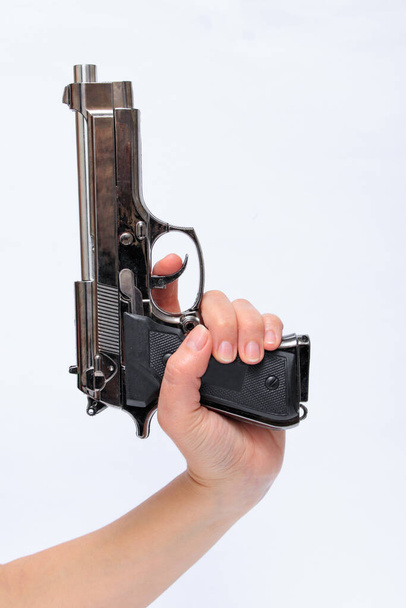 Жінка тримає пістолет в руці
 - Фото, зображення