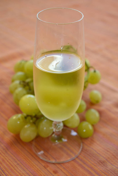 flute of white wine and bunch of grapes for a  concept of grape harvest - Foto, Imagen