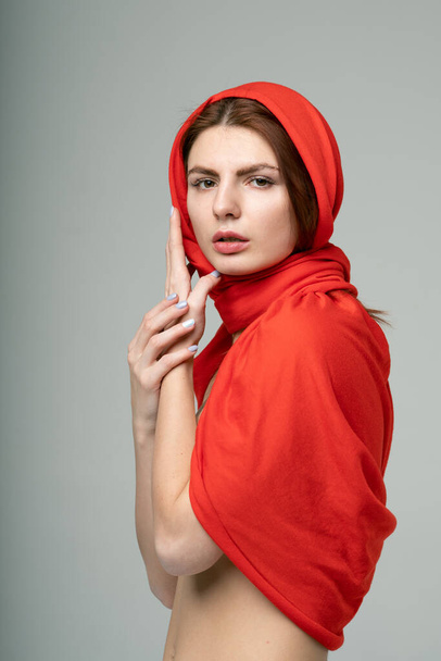 portrait of a young beautiful girl in a red scarf - 写真・画像
