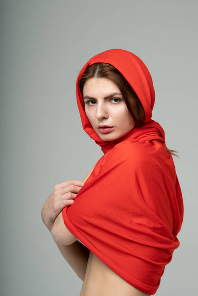 portrait of a young beautiful girl in a red scarf - Foto, afbeelding