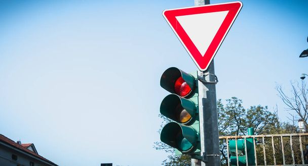 tricolor traffic light with a triangle sign giving way in Italy - 写真・画像