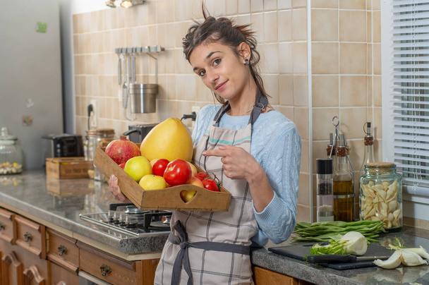 smiling young woman with various fruits in the kitchen - 写真・画像
