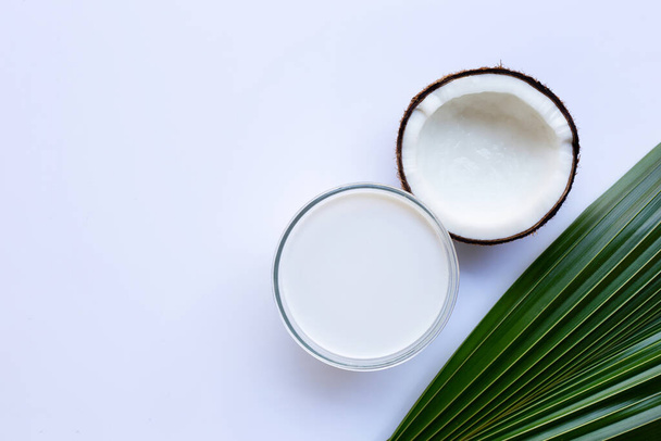 Half Coconut with glass bowl of coconut milk on white background. - 写真・画像