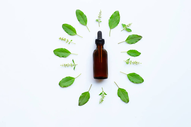 Holy Basil Essential Oil in a Glass Bottle with Fresh Holy Basil - Foto, Imagen