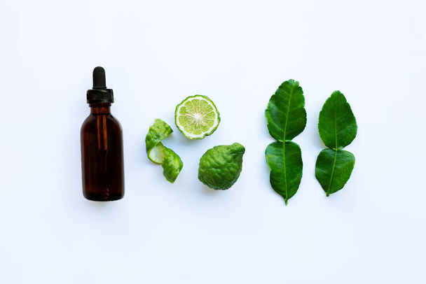Bottle of essential oil and  fesh bergamot fruit with leaves isolated on white background. - Фото, зображення